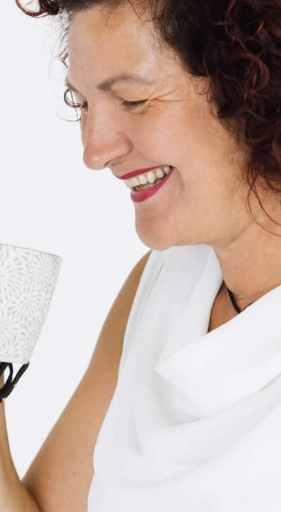 Christina Schaller lacht mit einer Tasse in der Hand